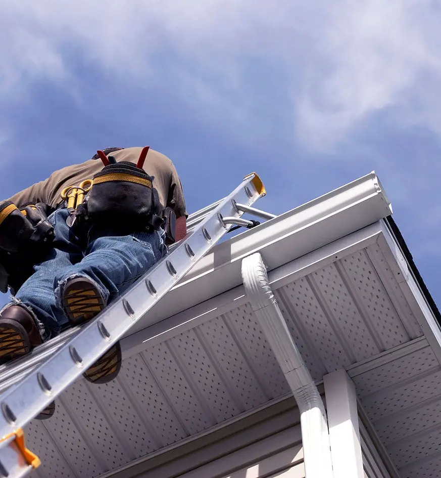 man on ladder working on gutters