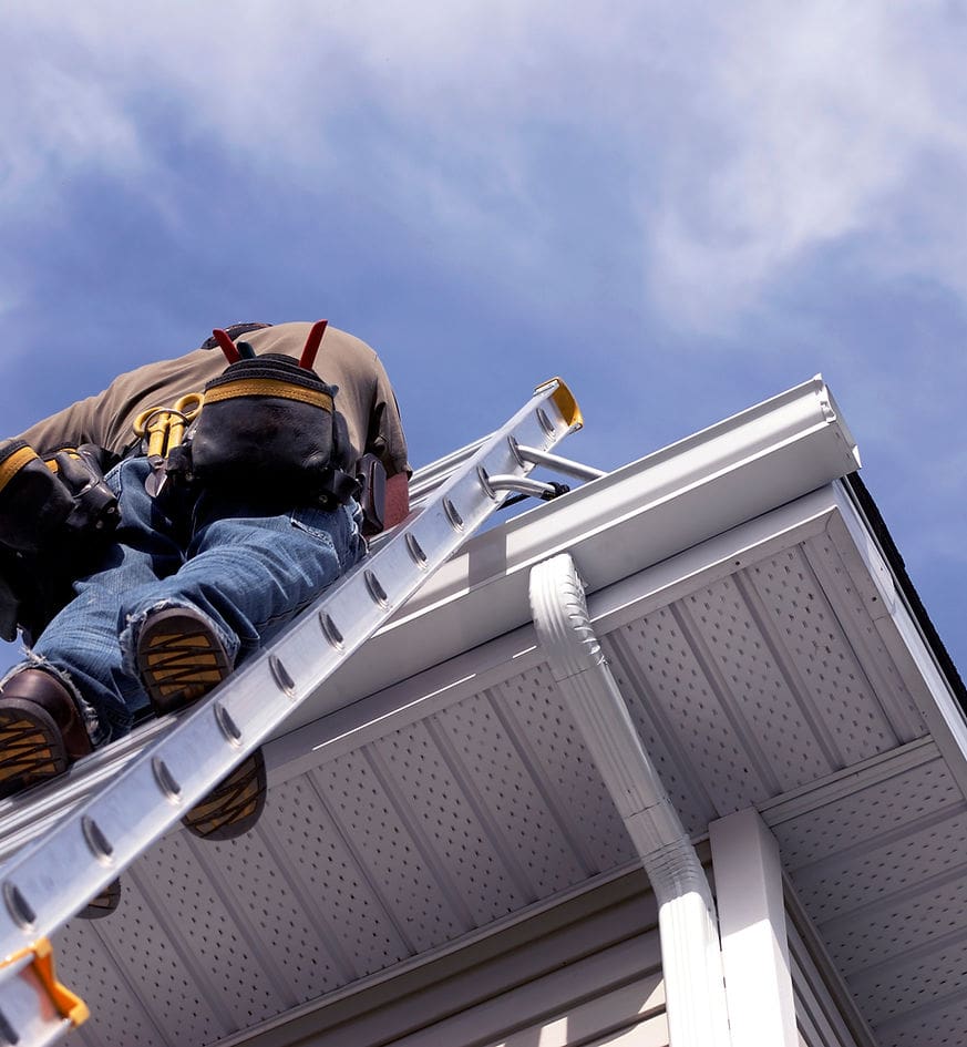 man on ladder working on gutters